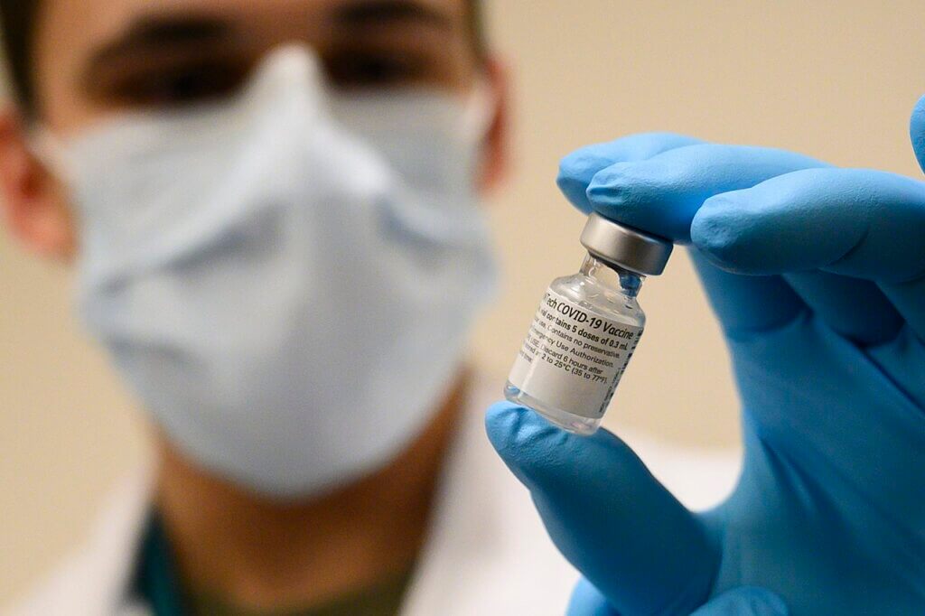 File Photo: Medical professional holds a vial of the Pfizer-BioNTech COVID-19 vaccine in December 2020. (Photo: Lisa Ferdinando/Wikimedia)