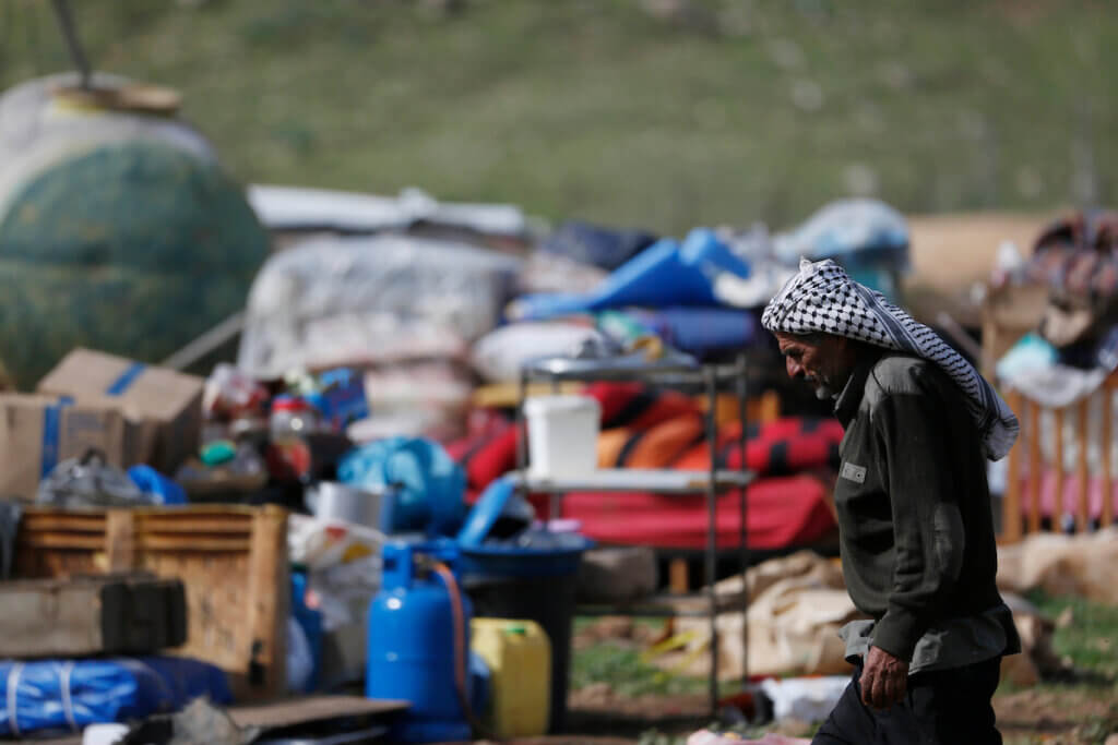 A Palestinian man walks next to his family's belongings near the site of their home which was dismantled by Israeli forces in Khirbet Humsah on February 2, 2021. (Photo: Shadi Jarar'ah/APA Images)