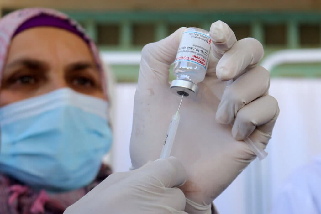 A Palestinian health worker holds a vial of the Moderna COVID-19 vaccine provided by Israel during vaccination in the West Bank city of Bethlehem on February 3, 2021.(Photo: Mosab Shawer/APA Images)