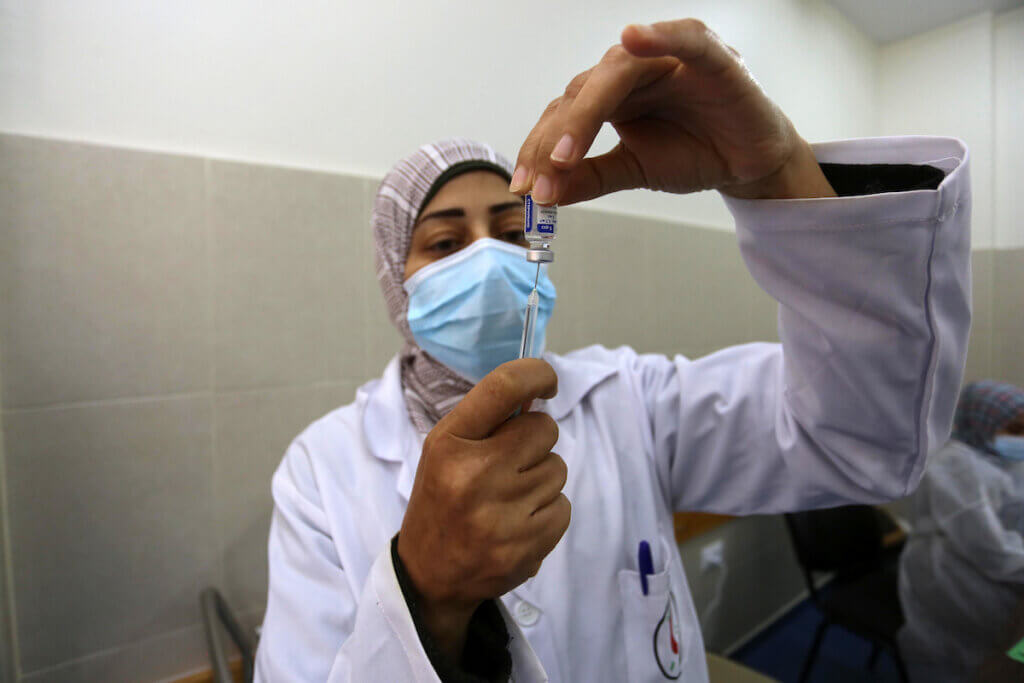 Palestinians receive doses of the coronavirus vaccine at a clinic in Khan Younis in the southern Gaza on March 16, 2021. (Photo: Ashraf Amra/APA Images)