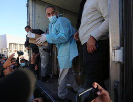 Workers unload boxes of the Russian-made COVID-19 vaccine, Sputnik V, donated from the United Arab Emirates at the Rafah crossing with Egypt on February 21, 2021. (Photo: Ashraf Amra/APA Images)