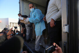 Workers unload boxes of the Russian-made COVID-19 vaccine, Sputnik V, donated from the United Arab Emirates at the Rafah crossing with Egypt on February 21, 2021. (Photo: Ashraf Amra/APA Images)
