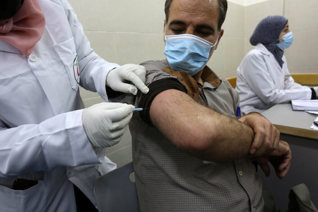 A Palestinian healthcare worker administers a dose of the Russian Sputnik V coronavirus vaccine to at European Hospital, in Khan Younis in southern Gaza on February 23, 2021. (Photo: Ashraf Amra/APA Images)