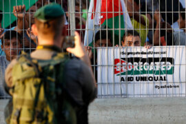 A member of Israeli security forces takes photos to Palestinian protesters during a demonstration in the West Bank city of Hebron on September 18, 2017. (Photo by Wisam Hashlamoun/APA Images)