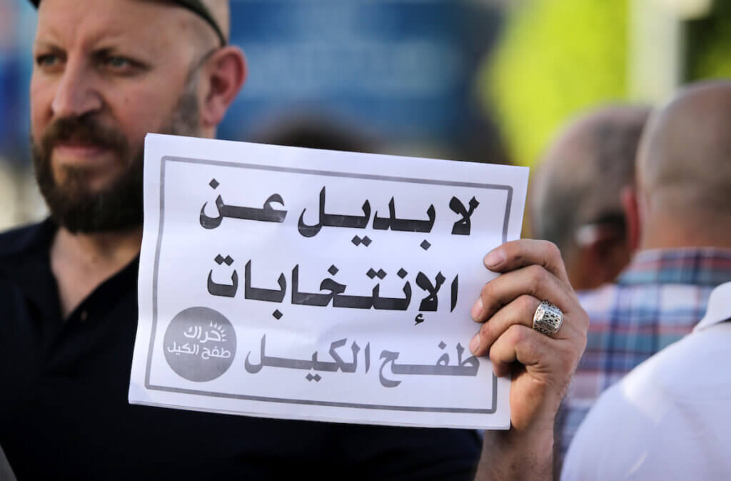 Palestinian candidates from several electoral lists demonstrated in Ramallah against the possible cancellation of elections, April 28, 2021. The sign here reads, "There is no substitute for the elections." (Photo: Ibrahim Attaia/APA Images)