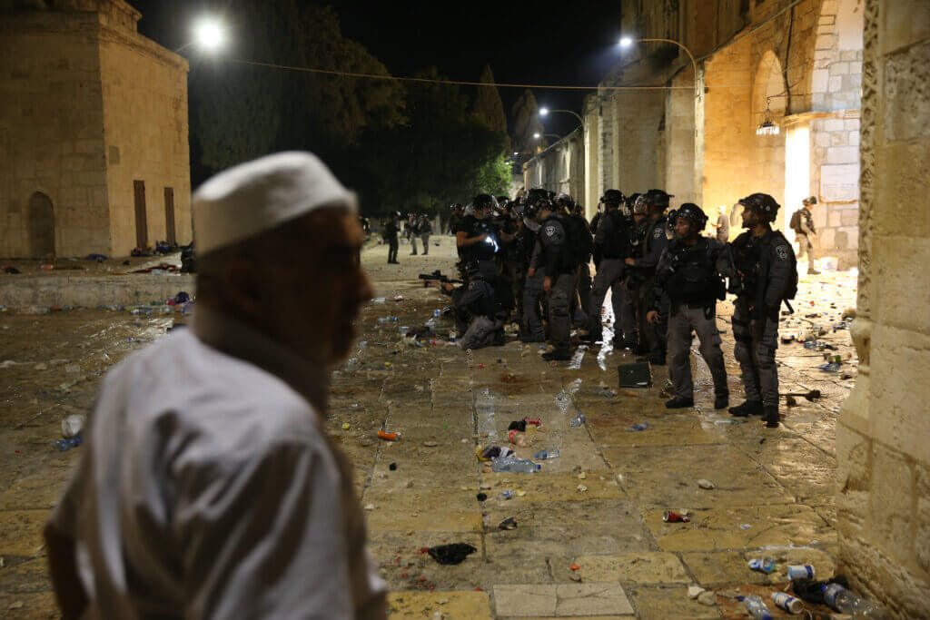 Israeli policemen gather during clashes with Palestinians at the compound that houses Al-Aqsa Mosque, known to Muslims as Noble Sanctuary and to Jews as Temple Mount, amid tension over the possible eviction of several Palestinian families from homes on land claimed by Jewish settlers in the Sheikh Jarrah neighbourhood, in Jerusalem, May 7, 2021. (Photo: Jamal Awad/APA Images.)