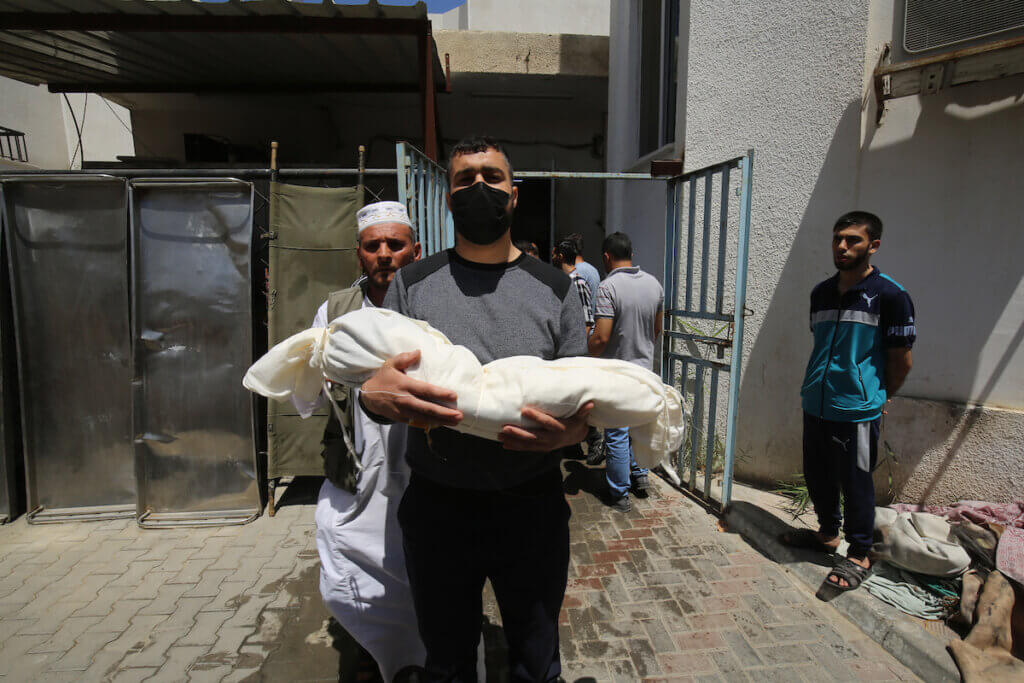 Palestinians carry the shrouded body of the toddler Ibrahim Alrantisi before his burial in Rafah in the southern Gaza Strip, on May 14, 2021. Alrantisi was one of the more than Palestinians who have been killed in Israeli air strikes this week. (Photo: Abed Deeb/APA Images)