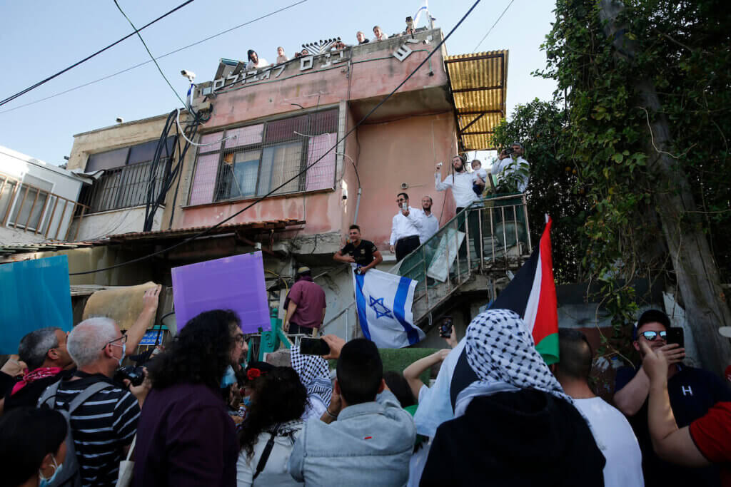 Activists demonstrate in front of a Palestinian house taken over by Israeli settlers in the Palestinian neighborhood of Sheikh Jarrah in Israeli-annexed East Jerusalem on April 16, 2021. (Photo: Jamal Awad/APA Images)
