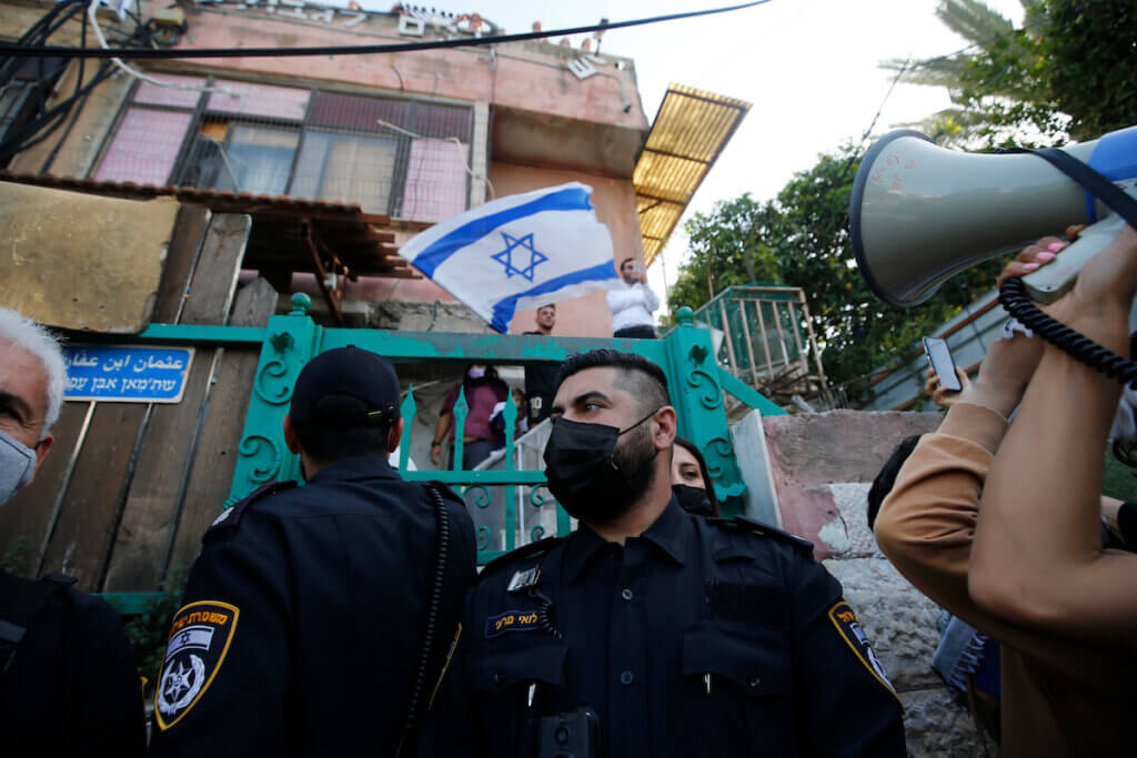 Israeli forces protect Israeli settlers outside a house in the Palestinian neighborhood of Sheikh Jarrah in occupied East Jerusalem on April 16, 2021. (Photo: Jamal Awad/APA Images)