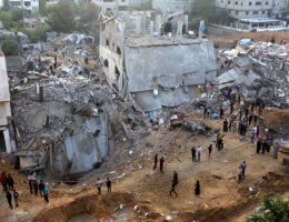 Palestinias asses the damage of a destroyed building on the first day of the Muslim Eid al-Fitr holiday in the northern Gaza Strip town of Beit Lahia, on May 13, 2021. (Photo: Ashraf Amra/APA Images)