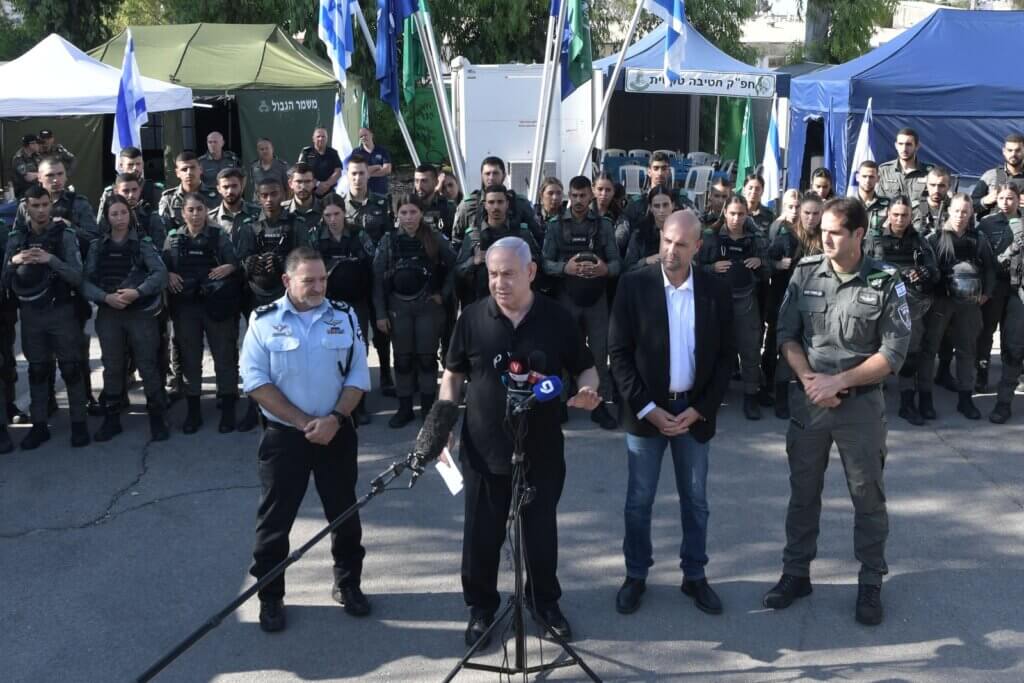 Benjamin Netanyahu and Minister of Public Security Amir Ohana (right) speak in front of phalanx of Israeli forces in Lydd (Lod), May 13, 2021 (Photo: Twitter)