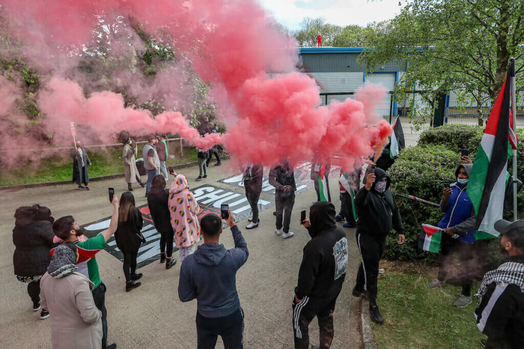 Leicester, United Kingdom, May 19, 2021: People hold red flares as they gathered to support UK based Pro-Palestinian activists group "Palestine Action" who seized control of the Leicester based factory of Elbit subsidiary UAV Tactical Systems on Wednesday, May 19, 2021. Activists say that "the occupation is aiming to be as disruptive as possible; these activists are determined to prevent Elbit from resuming its business of bloodshed." (Photo by Vudi Xhymshiti/VXP)