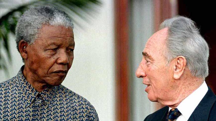  Then-South African President Nelson Mandela exchanges a look with then-Israeli Prime Minister Shimon Peres after a meeting in Cape Town, Oct. 20, 1996. - REUTERS