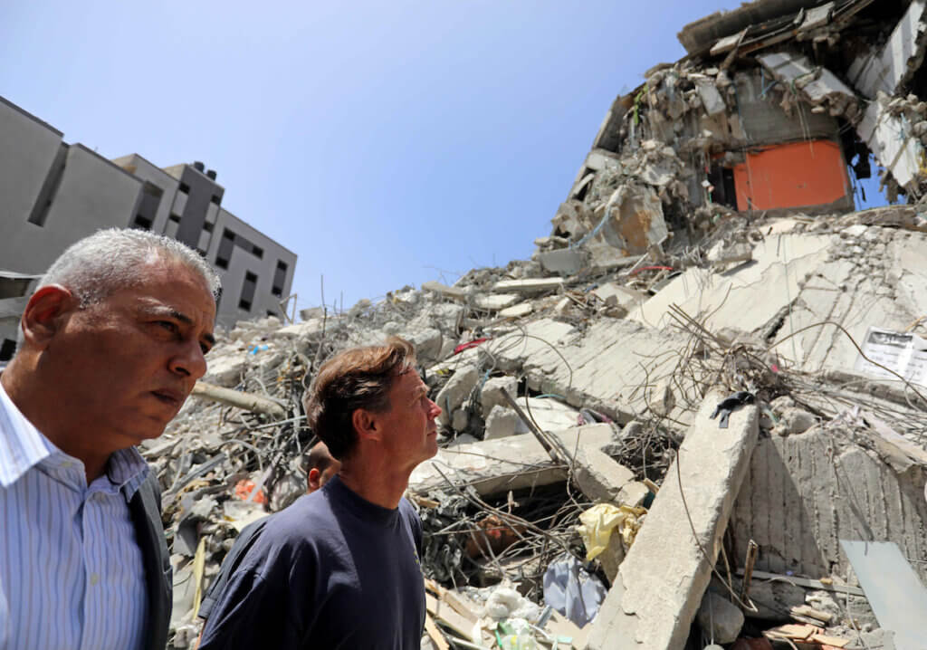 Sven Kühn von Burgsdorff, European Union Representative to the West Bank and Gaza, is given a tour of the ruins of al-Shouroq tower, destroyed by Israeli strikes during the recent confrontations between Hamas and Israel, in Gaza City on June 1, 2021. (Photo: Ashraf Amra/APA Images)