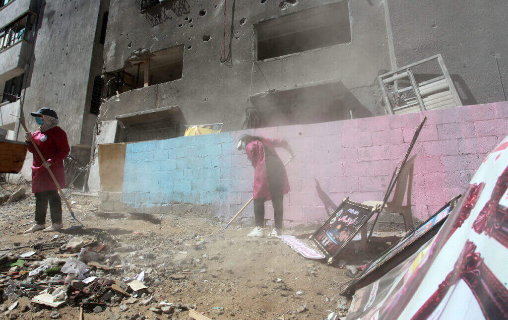Palestinians paint and plant trees on the land of Abu Hatab family house that was destroyed in an Israeli air trike earlier in the Shati beach refugee camp in Gaza on 17 June 2021. (Photo: Omar Ashtawy/APA Images)