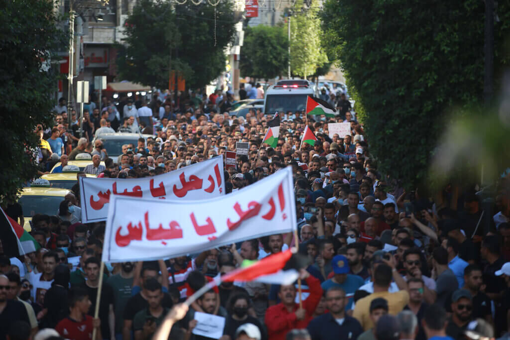 Palestinian demonstrators protesting Palestinian President Mahmoud Abbas in the aftermath of the death of activist Nizar Banat lift banners which say "Leave" during a rally in Ramallah in the occupied West Bank on July 3, 2021. (Photo: STR/APA Images)