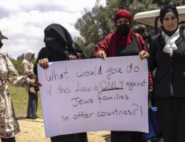 Palestinian citizens of Israel hold a sign during a protest ahead of a vote by Israel's parliament on renewing a law that bars Palestinian citizens from extending citizenship or even residency to spouses from the occupied West Bank and Gaza, outside the parliament building in Jerusalem, Monday, July 5, 2021. (Photo: AP Photo/Tsafrir Abayov)
