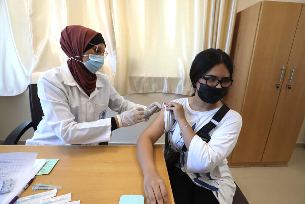 Palestinians receive the coronavirus vaccine at a UNRWA clinic in Gaza City on July 27, 2021. (Photo: Ashraf Amra/APA Images)