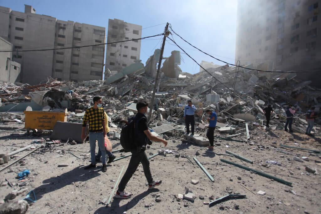 Palestinians inspect rubbles at the Jalaa tower after it is destroyed in an Israeli airstrike on Gaza City on May 15, 2021. (Photo: Naaman Omar/APA Images)