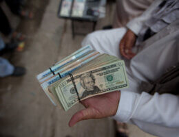 Widespread corruption permeated the highest levels of the Government of the Islamic Republic of Afghanistan. Here, a money changer displays his currency wares at the bazaar. (Photo: Institute for Money, Technology and Financial Inclusion)