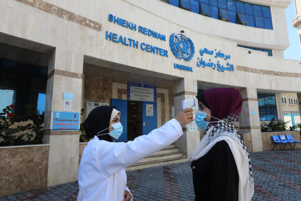 Palestinians receive a temperature check outside of a coronavirus vaccine site administered at an UNRWA clinic in Gaza City on July 27, 2021. (Photo: Ashraf Amra/APA Images)