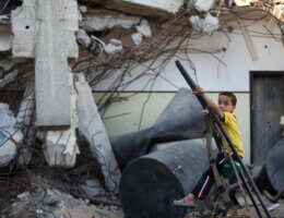 A Palestinian boy plays on the ruins of houses destroyed by Israeli shelling in the east of Gaza City on July 8, 2015. The majority of children living in areas of Gaza hardest-hit during last year's conflict are showing signs of severe emotional distress and trauma, including frequent bed wetting and nightmares, according to UNICEF. (Photo: Ashraf Amra/APA Images)