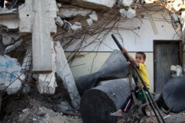 A Palestinian boy plays on the ruins of houses destroyed by Israeli shelling in the east of Gaza City on July 8, 2015. The majority of children living in areas of Gaza hardest-hit during last year's conflict are showing signs of severe emotional distress and trauma, including frequent bed wetting and nightmares, according to UNICEF. (Photo: Ashraf Amra/APA Images)