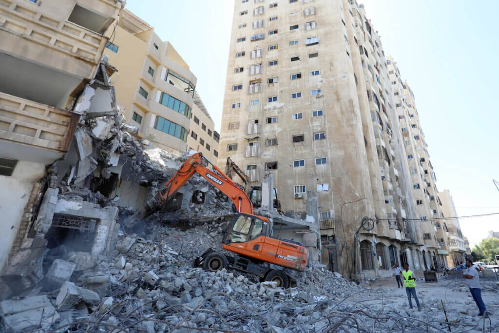 Palestinian workers remove the rubble of a building in Gaza City which was hit by Israeli strikes during the 11-day conflict between Israel and Hamas on May, on September 19, 2021. (Photo: Ashraf Amra/APA Images)