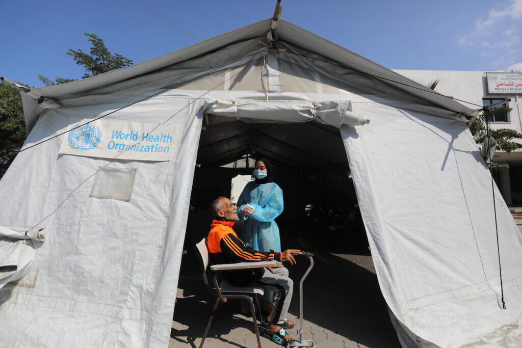 A Palestinian health worker collects a swab sample for a COVID-19 test at a temporary vaccination center set up in Gaza City on October 23, 2021. (Photo: Ashraf Amra/APA Images)