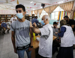 Palestinian high school students get inoculated with a dose of the Covishield vaccine at a school in Nuseirat refugee camp in the central Gaza Strip on September 1, 2021. (Photo: Ashraf Amrac/APA Images)