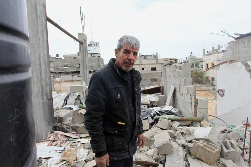 The owner of a home destroyed by an Israeli air-strike in May 2021 stands in their in Beit Hanoun in the northern of Gaza Strip on December 09, 2021. Owners of houses partially or totally destroyed during the May war on Gaza are concerned about the delayed reconstruction. (Photo: Youssef Abu Watfa/APA Images)