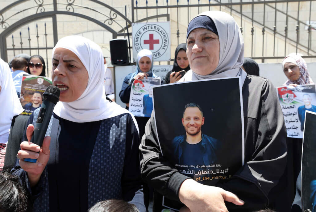 The mother of deceased Palestinian Bilal Rawajba, right, holds up his picture during a protest outside the Red Cross offices in the West Bank city of Nablus on August 15, 2020 to call for the handing over of his body as well as the corpses of other Palestinians held by Israel. (Photo: APA Images)