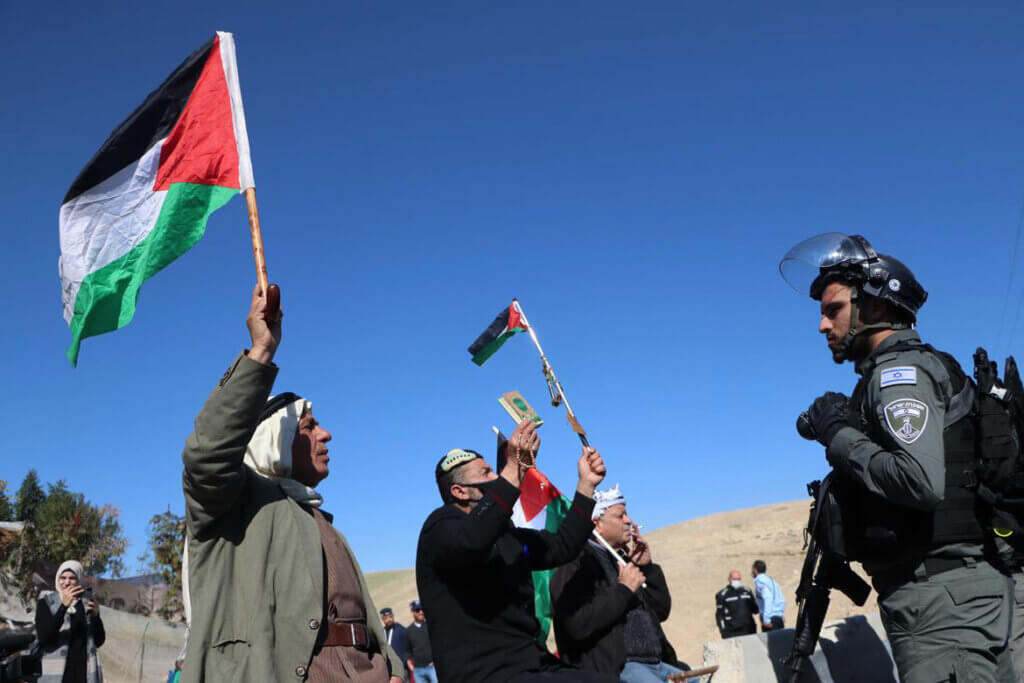 Palestinians face off with Israeli troops during a protest against Israeli policy in the Naqab desert and to demand the legalization of the unrecognized villages there, in the Palestinian Bedouin village of Khan al-Ahmar, east of Jerusalem on January 30, 2022. Photo by WAFA