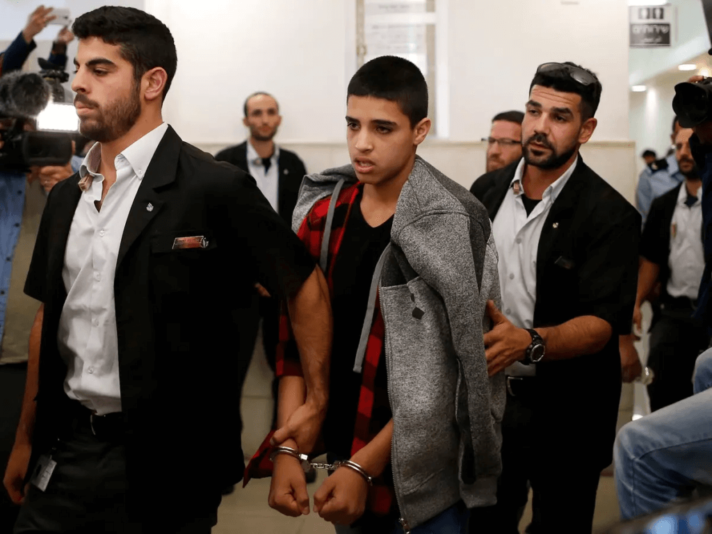 14-year old Ahmed Manasra (center) leaving the District Court in Jerusalem after his sentencing hearing on November 7, 2016. The court sentenced Manasra to 12 years in jail for the alleged attempted murder of two Israelis; this sentence was later reduced to nine and a half years. (Photo: AFP)
