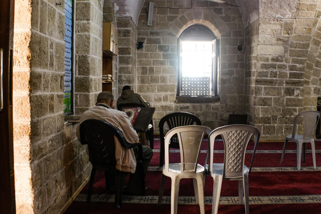 Two men seen sitting in the 600 year old mosque Sayed Al-Hashem, reading the Quran during the holy month of Ramadan. Gaza, April 4, 2022