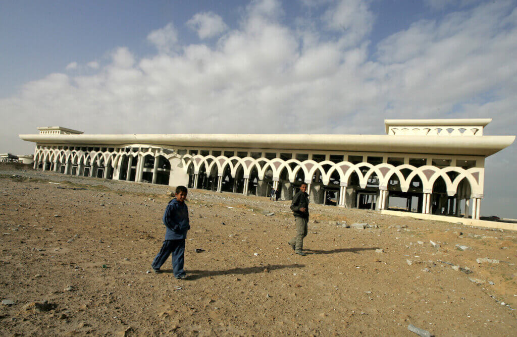 Palestinians walk by the Gaza International Airport after an air strike by Israeli warplanes in Rafah, on February 3, 2010. (Photo: Abed Rahim Khatib/APA Images)