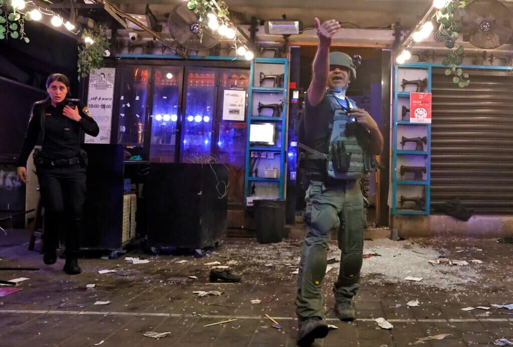 Un poliziotto fa un gesto sulla scena all'indomani di una sparatoria in Dizengoff Street a Tel Aviv, 7 aprile 2022. (AFP tramite Getty Images)