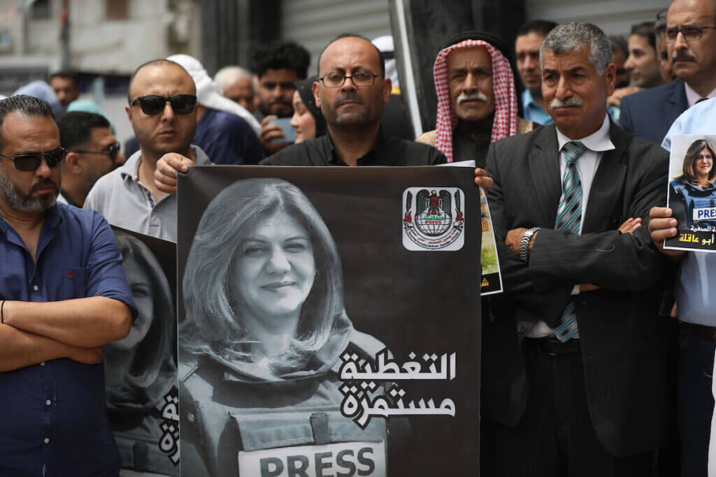 Palestinian journalists hold posters during a protest against the killing of Al Jazeera journalist Shireen Abu Akleh, who was, shot dead by Israeli troops as she covered a raid on the West Bank's Jenin refugee camp, in Gaza City on May 11, 2022. (Photo: Ashraf Amra/APA Images)