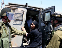 A Palestinian woman is detained by Israeli soldiers during a demonstration against Israeli occupation and settlements expansion, on July 15, 2011 in the West Bank village of Nabi Saleh (Photo: Issam Rimawi/APA Images)