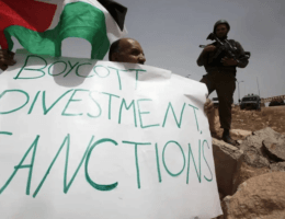 A Palestinian holds a placard reading "Boycott Divestment, Sanctions" as part of a protest on June 8, 2013 near the Jewish settlement of Bat Ayin and the West Bank village of Surif, west of Hebron. (Photo: Hazem Bader/AFP via Getty Images)