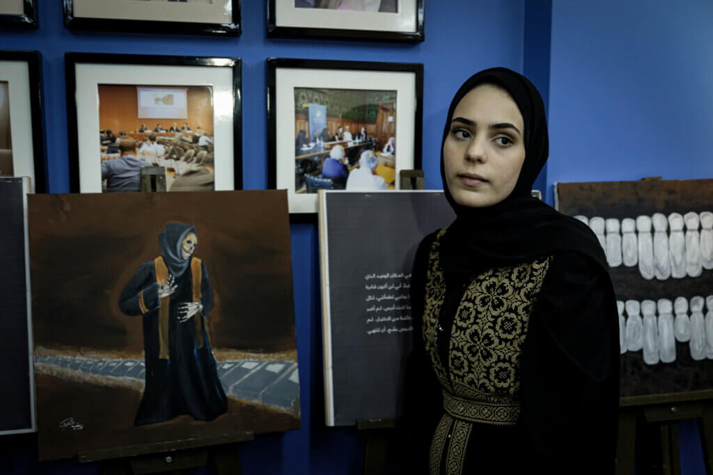 Zainab al-Qolaq with one of her paintings depicting the figure of death. (Photo: Mohamed Salem)(Photo: Mohamed Salem)