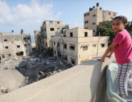 Palestinians look out at a heavily damaged building in Gaza city on August 8, 2022, following a cease fire between Israel and Palestinians. (Photo: Ashraf Amra/APA Images)