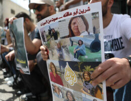 Palestinian journalists hold posters displaying Al Jazeera reporter Shireen Abu Akleh on May 11, 2022, in the West Bank city of Hebron. The poster reads in Arabic, "the Martyrdom of Journalist Shireen Abu Akleh". (Photo: Mamoun Wazwaz/APA Images)