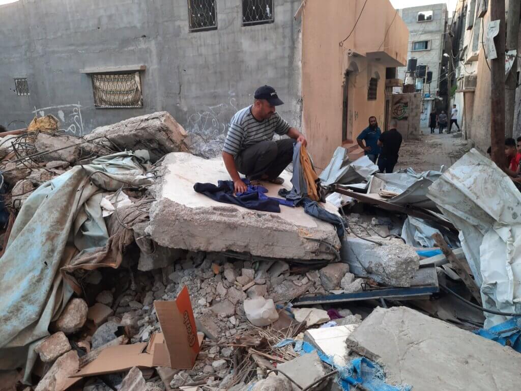 Ashraf Qaisy sitting with the rubble of his home. (Photo: Ahmed Al-Sammak)