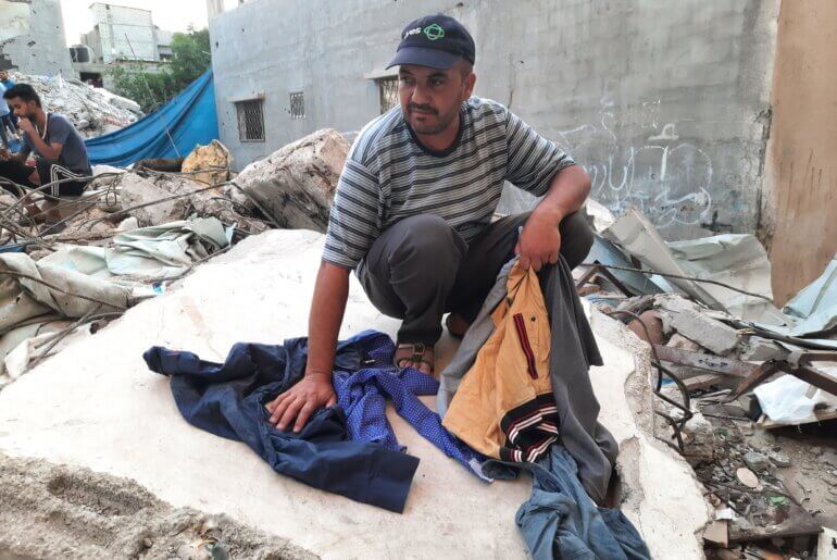 Ashraf Qaisy sitting on the rubble of his home. (Photo: Ahmed Al-Sammak)