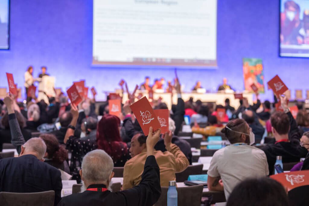 Assembly participants raise orange consensus cards in affirmation of what is said during a closing business plenary at the 11th Assembly of the World Council of Churches, held in Karlsruhe, Germany. (Photo: Albin Hillert/WCC)