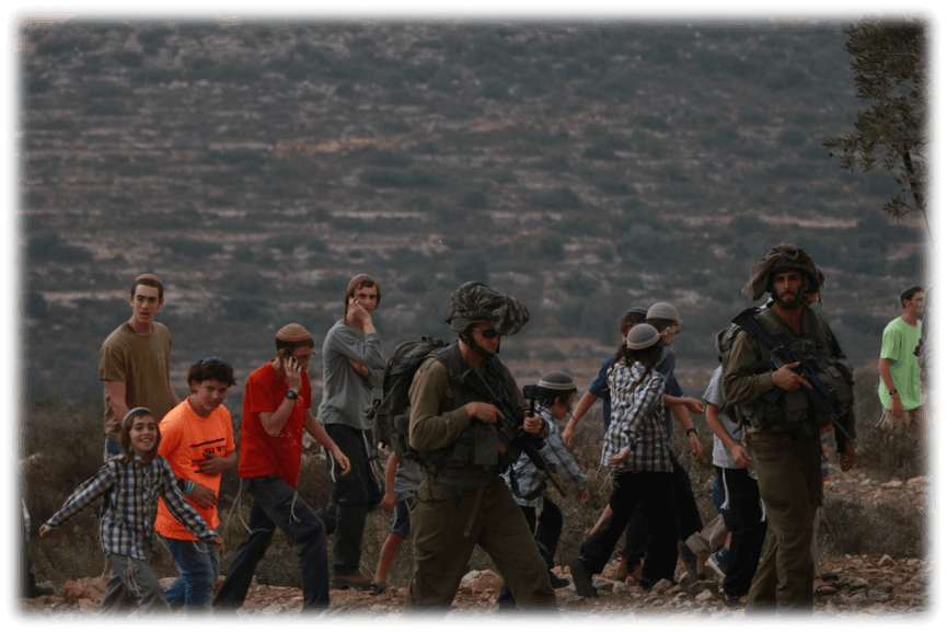 Israeli settlers marching with military protection on Naalan mountain. (Photo: Mohammad Shreiteh)