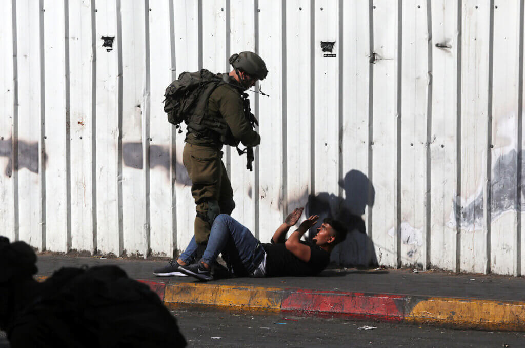 Israeli forces detain a Palestinian demonstrator during protests in the West Bank city of Hebron following the killing of Udai Tamimi, on October 20, 2022. (Photo: Mamoun Wazwaz/APA Images)