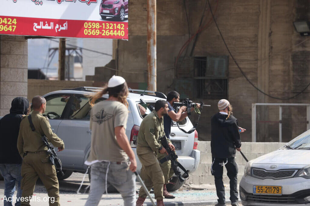 Israeli settlers and soldiers during the attack on Huwwara on October 13, 2022. (Photo: Oren Ziv/Activestills)
