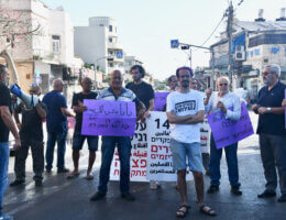 An activist holds a sign that says, "Jaffa is not for sale," as protesters obstruct traffic during a demonstration against the displacement of Palestinians in Jaffa. (Photo: Jessica Buxbaum)